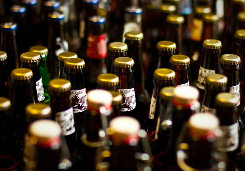 De nombreuses bouteilles de bières alignées, des capsules de bières à perte de vue.De nombreuses bouteilles de bières alignées, des capsules de bières à perte de vue.