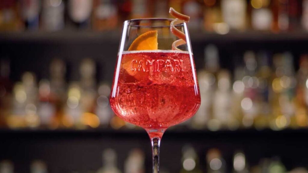 Alternative de spritz campari apertif festif visible en premièr plan, en arrière plan un arrière bar flou